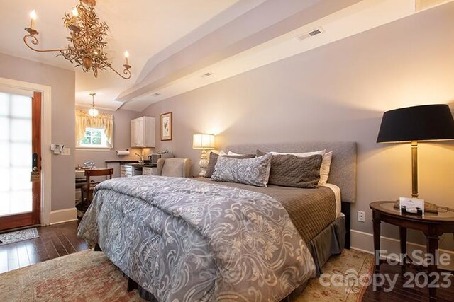 bedroom with dark hardwood / wood-style floors and a notable chandelier