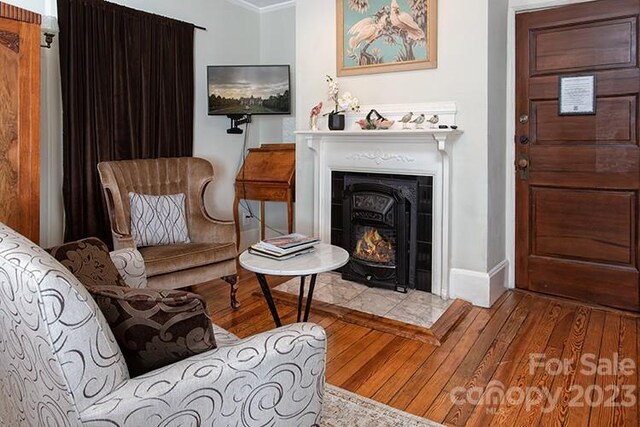 sitting room with light hardwood / wood-style floors and ornamental molding