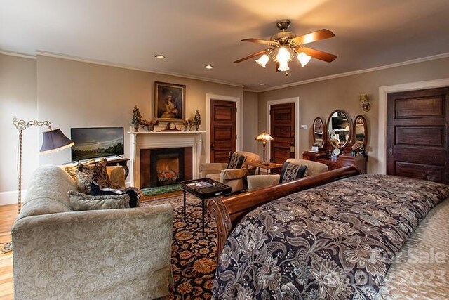 bedroom featuring ceiling fan, light hardwood / wood-style flooring, and ornamental molding