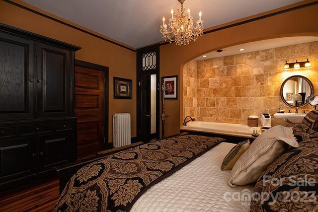 bedroom featuring crown molding, radiator heating unit, dark wood-type flooring, and a notable chandelier