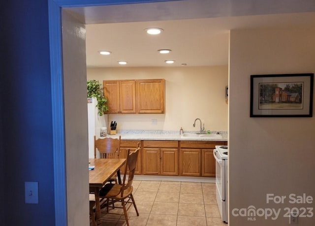 kitchen featuring sink, light tile patterned flooring, and white electric range