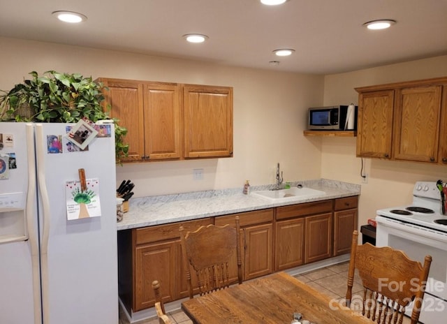 kitchen featuring light tile patterned floors, sink, light stone counters, and white appliances