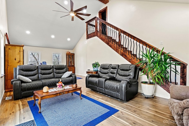 living room with ceiling fan, light wood-type flooring, and high vaulted ceiling