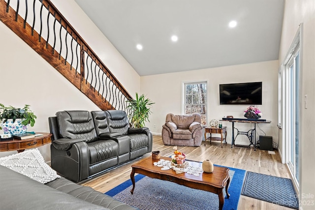 living room featuring light wood-type flooring and lofted ceiling