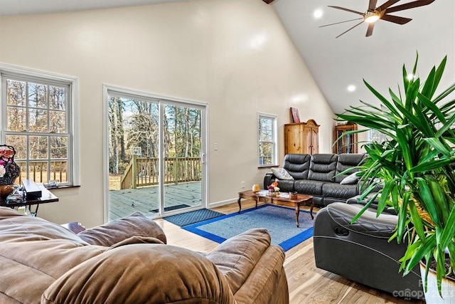 living room featuring light wood-type flooring, high vaulted ceiling, and ceiling fan