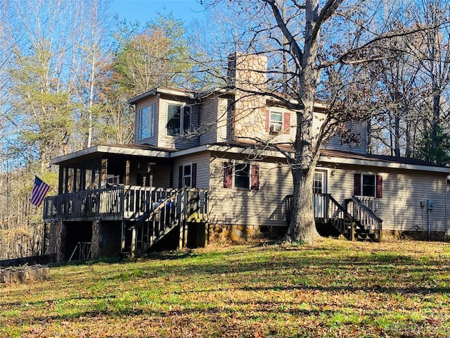 rear view of property featuring a deck and a yard