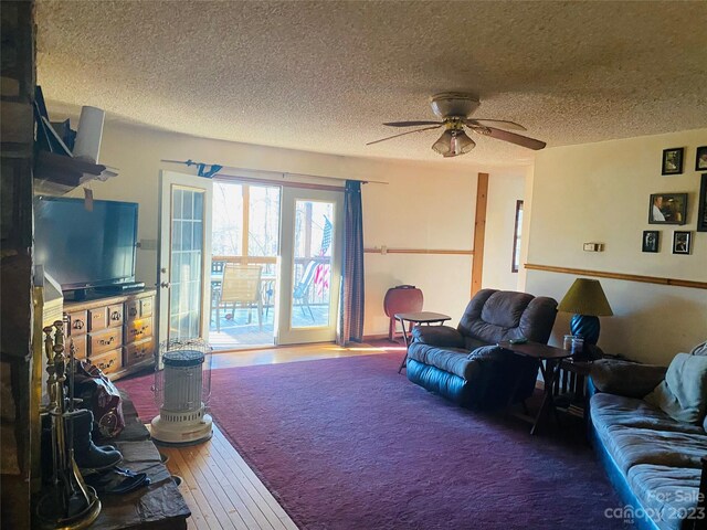 living room with hardwood / wood-style flooring, a textured ceiling, and ceiling fan