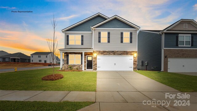 craftsman inspired home featuring a lawn and a garage