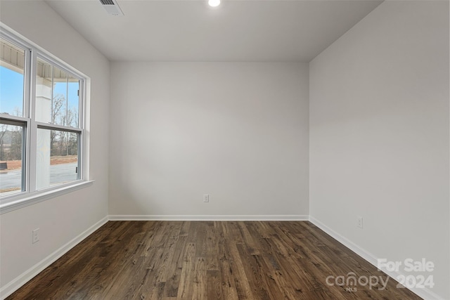 unfurnished room featuring a healthy amount of sunlight and dark hardwood / wood-style flooring