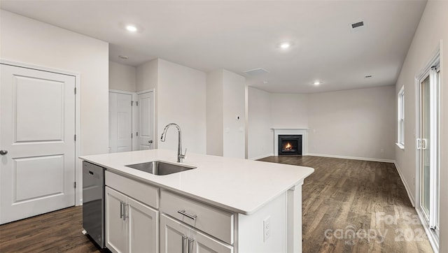 kitchen featuring white cabinets, sink, dishwasher, dark wood-type flooring, and a kitchen island with sink