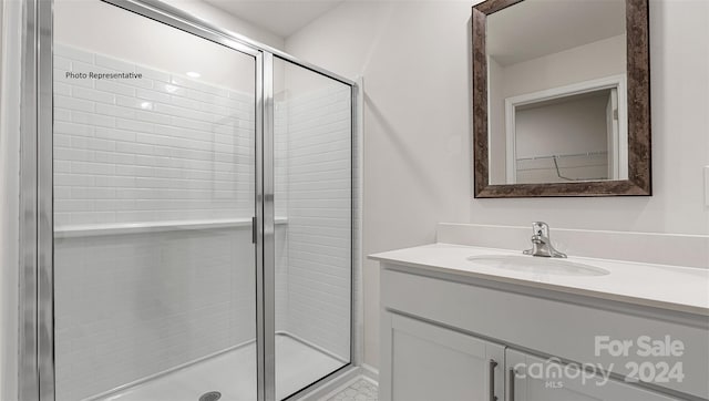 bathroom featuring a shower with door and vanity