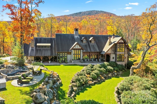 back of property featuring a lawn and a mountain view