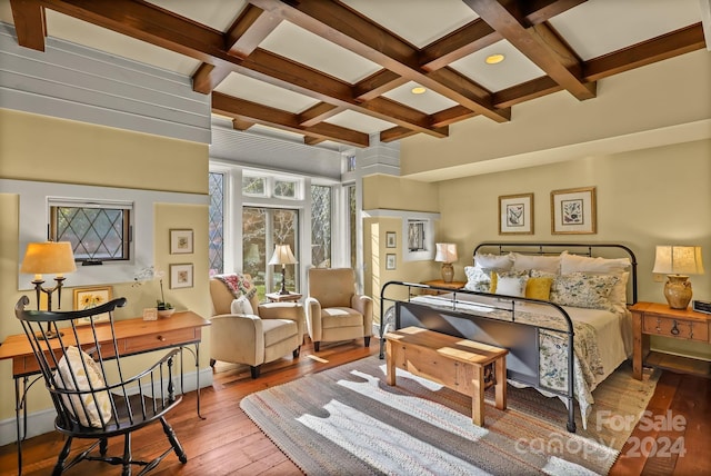 bedroom with light hardwood / wood-style floors, beam ceiling, and coffered ceiling