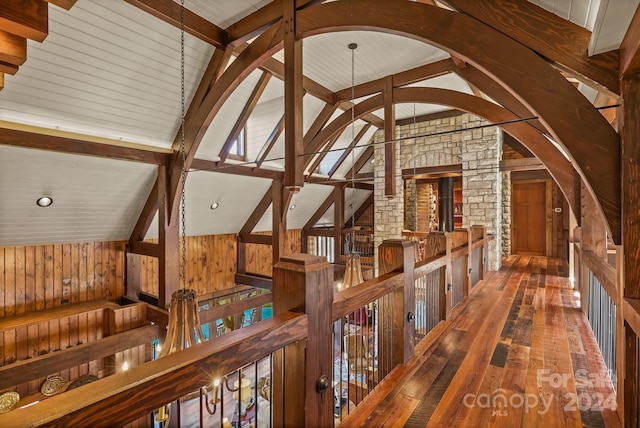 room details featuring wooden walls, wood-type flooring, and beam ceiling