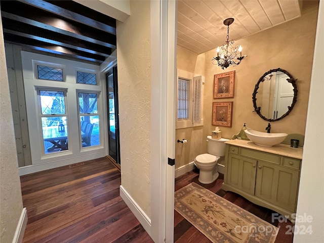 bathroom with wood-type flooring, toilet, a chandelier, vanity, and beamed ceiling