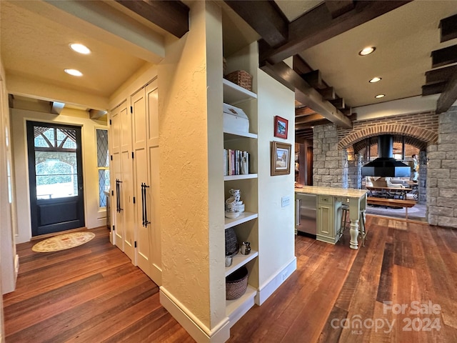 interior space with dark wood-type flooring and beamed ceiling