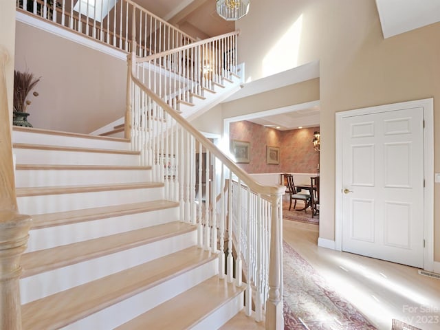 stairway with a towering ceiling and hardwood / wood-style flooring