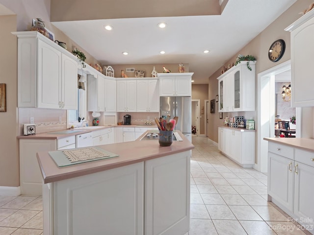 kitchen featuring stainless steel fridge with ice dispenser, a center island, light tile patterned floors, and white cabinets