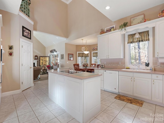 kitchen featuring backsplash, a kitchen island, white cabinets, white dishwasher, and sink