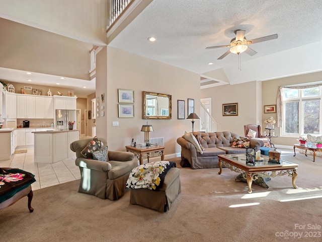 living room with light tile patterned floors, high vaulted ceiling, ceiling fan, and a textured ceiling