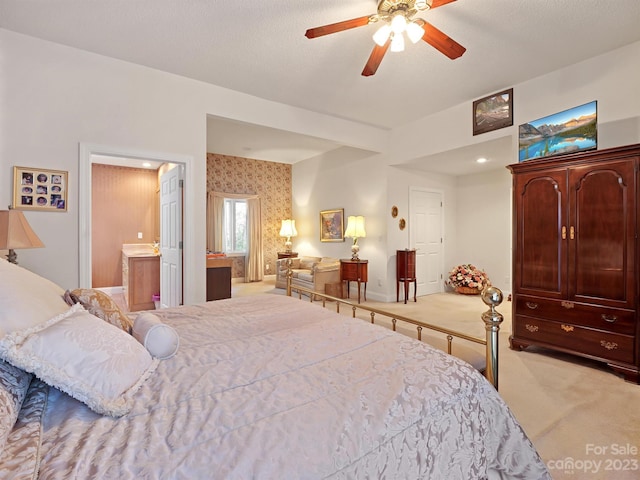 bedroom featuring ceiling fan, light carpet, and ensuite bath