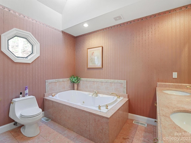 bathroom with tile patterned flooring, dual bowl vanity, tiled bath, and toilet