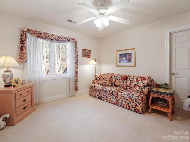 carpeted living room with ceiling fan