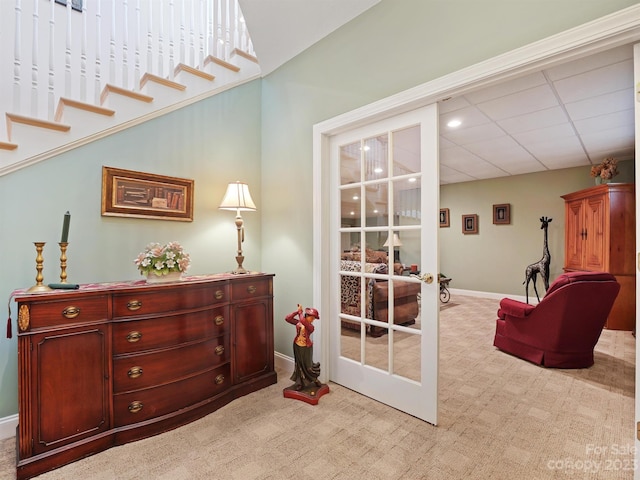 interior space featuring light colored carpet, french doors, and a paneled ceiling