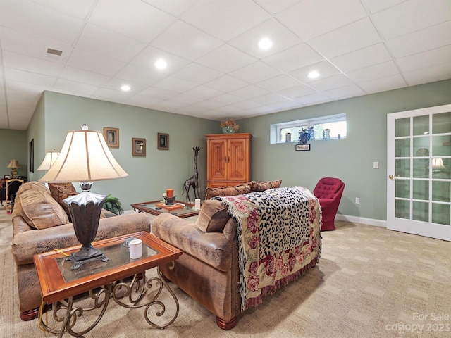 carpeted living room with a drop ceiling