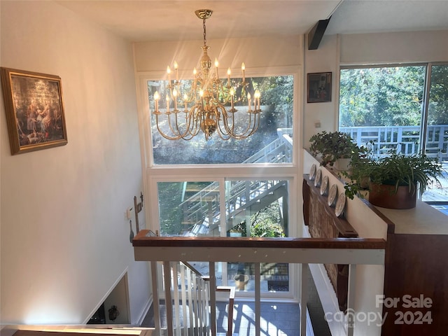 stairs featuring a notable chandelier