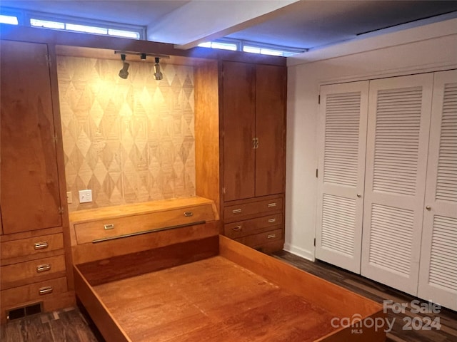 unfurnished bedroom featuring a closet and dark hardwood / wood-style flooring