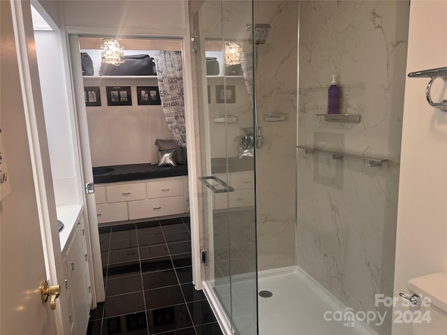 bathroom with a shower with shower door, toilet, tile flooring, and vanity