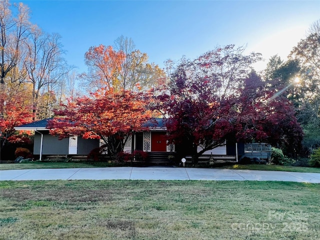 view of property hidden behind natural elements with a front yard