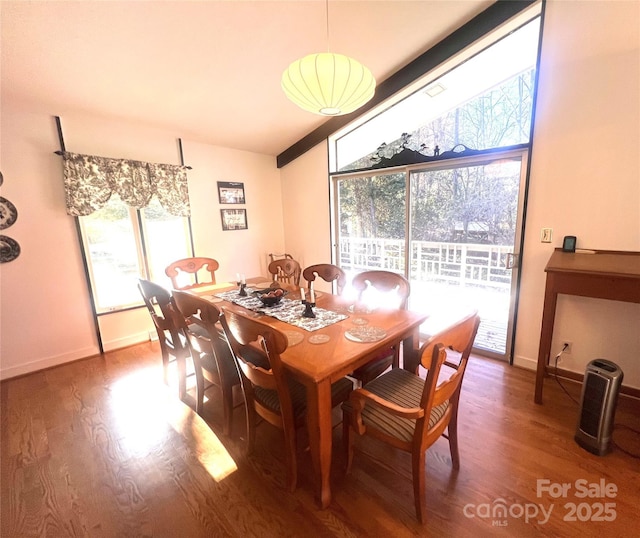 dining area featuring lofted ceiling, baseboards, and wood finished floors