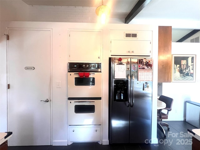 kitchen with visible vents, white cabinets, white double oven, stainless steel fridge with ice dispenser, and beamed ceiling