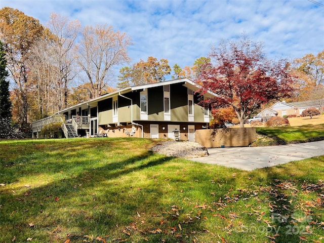 back of property featuring stairs, a lawn, and stucco siding