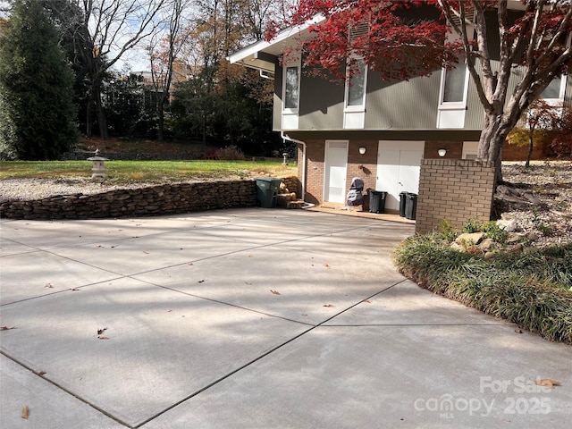 exterior space featuring driveway and brick siding