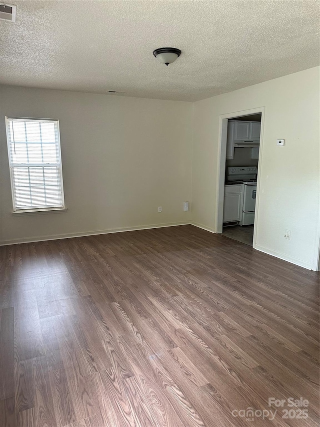 unfurnished room featuring dark hardwood / wood-style flooring and a textured ceiling