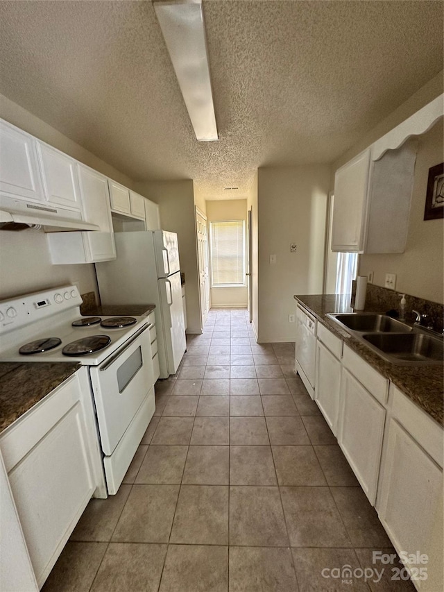 kitchen featuring a textured ceiling, white appliances, sink, tile patterned flooring, and white cabinetry