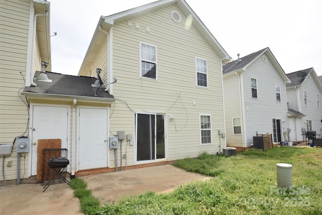 back of property with a lawn and a patio area