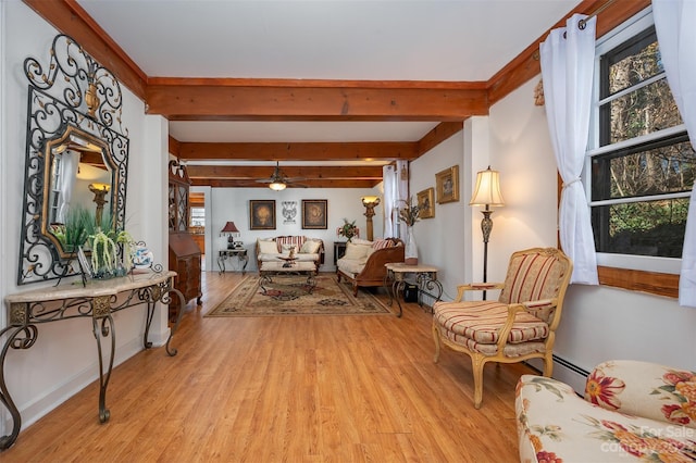 sitting room featuring ceiling fan, a healthy amount of sunlight, beamed ceiling, and light hardwood / wood-style flooring