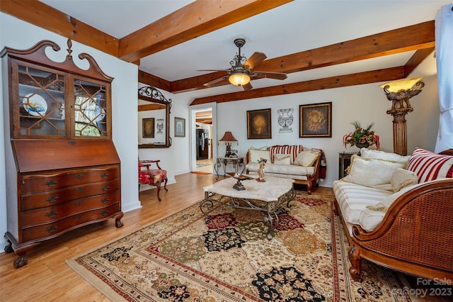 living room with light wood-type flooring, ceiling fan, and beamed ceiling