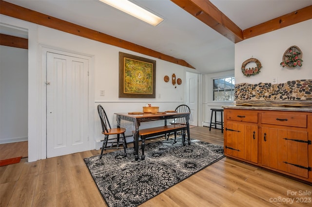 dining area featuring lofted ceiling, light hardwood / wood-style flooring, and a baseboard radiator