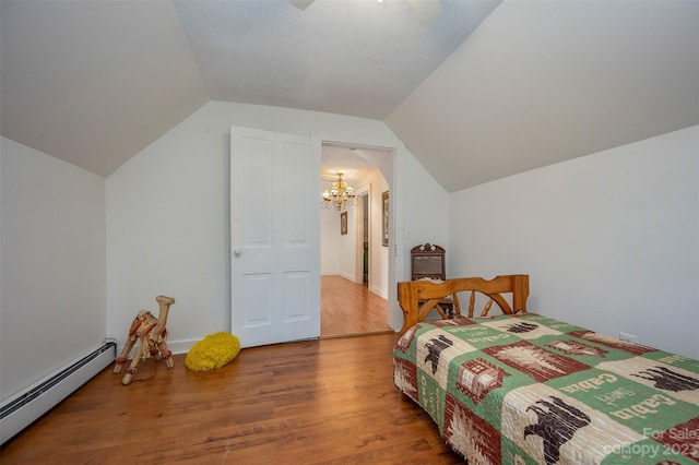 bedroom with a baseboard heating unit, lofted ceiling, ceiling fan with notable chandelier, and hardwood / wood-style flooring