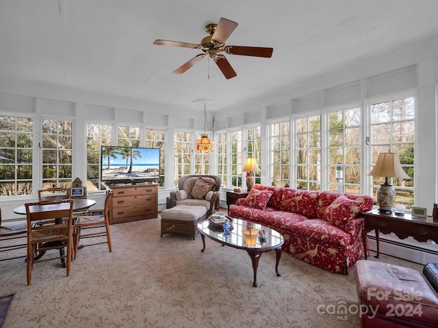 sunroom featuring a baseboard heating unit and ceiling fan