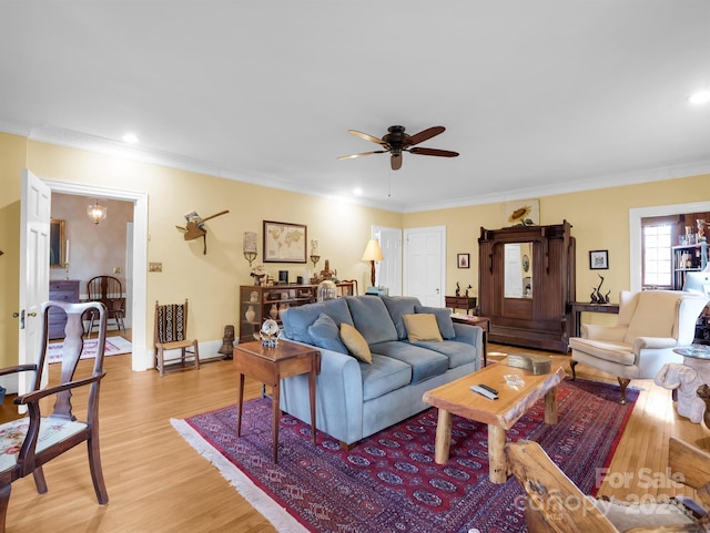 living room with light wood-type flooring, crown molding, and ceiling fan