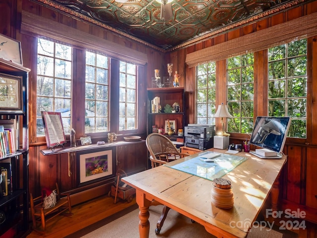 office space featuring hardwood / wood-style flooring, wooden walls, and a healthy amount of sunlight