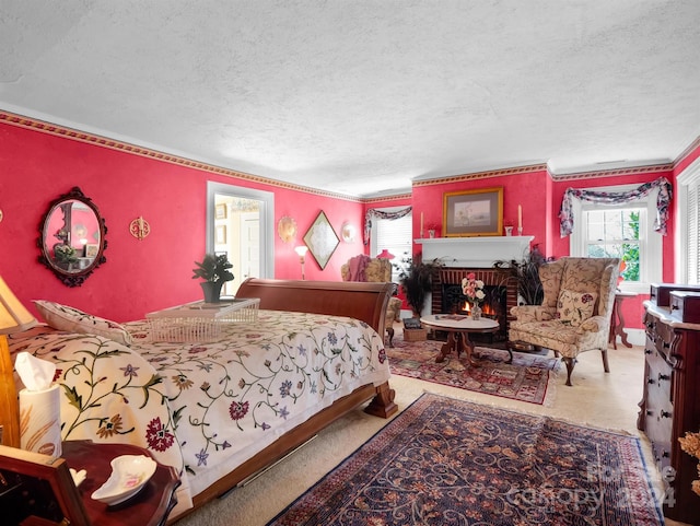 bedroom featuring a textured ceiling, crown molding, a brick fireplace, and carpet floors