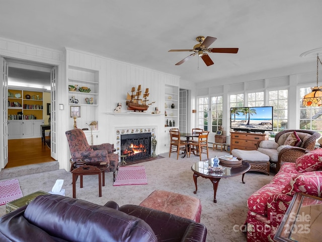 429 S Ridgecrest Ave, Rutherfordton, NC 28139 - carpeted living area featuring a fireplace with flush hearth, a ceiling fan, built in features, and ornamental molding
