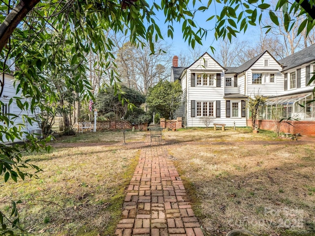 429 S Ridgecrest Ave, Rutherfordton, NC 28139 - back of property featuring a chimney, a sunroom, and a lawn